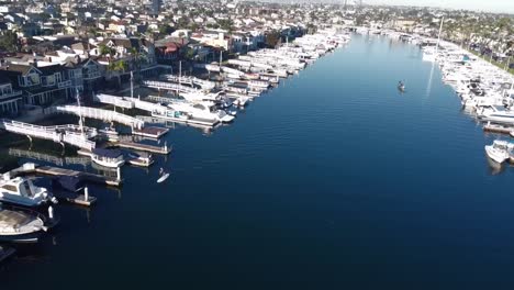 Fly-over-houses-with-boat-docks,-bridge-and-boats,-drone-shot
