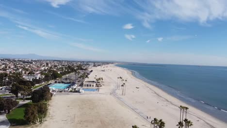 Drone-shot-over-beach-and-a-swimming-pool-next-to-a-park