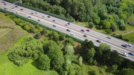 Highway-Surrounded-By-Lush-Vegetation-With-Vehicles-Traveling-In-Gdynia,-Poland---aerial-drone-shot