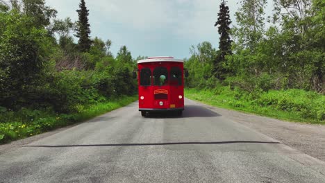 Roter-Oberleitungsbus,-Der-Langsam-Auf-Der-Straße-Im-Ländlichen-Alaska-Fährt---Weitschuss
