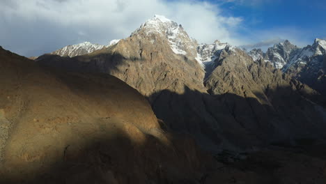 Cinematic-aerial-shot-of-Tupopdan-Peak,-Passu-Cones-in-Hunza-Pakistan,-snow-covered-mountain-peaks-with-steep-cliffs,-wide-revealing-drone-shot