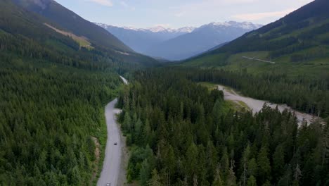 Aerial-Of-Cars-Driving-Across-Duffey-Lake-Road-Through-Forests-And-Coastal-Mountains-In-British-Columbia,-Canada