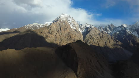 Cinematic-drone-shot-of-Tupopdan-Peak,-Passu-Cones-in-Hunza-Pakistan,-snow-covered-mountain-peaks-with-steep-cliffs,-high-wide-panning-aerial-shot