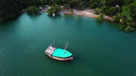 A-Wooden-Dhow-Boat-Floating-On-Calm-Turquoise-Waters-Of-Kilifi-Creek,-Kenya,-Eastern-Africa
