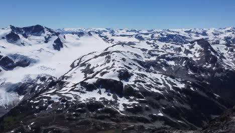Luftdrohne-Unglaubliche-Landschaft-Schneebedeckte-Berge-Schwenkschuss-Pazifische-Gebirgszüge-Kanada