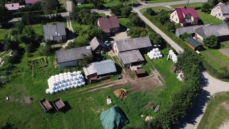 Luftaufnahme-Mit-Drohne-Von-Dorfhäusern-Mit-In-Plastik-Eingewickelten-Heuballen
