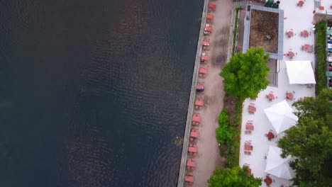 Beer-garden-on-the-lake,-white-umbrellas-Amazing-aerial-view-flight-bird's-eye-view-drone-footage-of-lake-schlachtensee-Berlin-golden-summer-sunset-2022-4k-Cinematic-view-from-above-by-Philipp-Marnitz