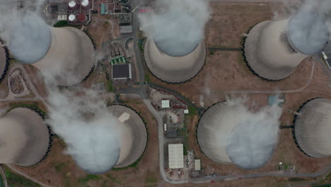 Top-down-slider-drone-shot-of-Large-power-plant-cooling-towers-from-above
