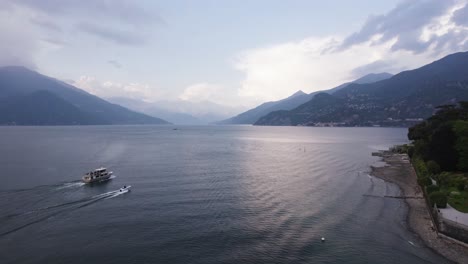 Boats-Sailing-On-Lake-Como-In-Bellagio,-Italy-With-Majestic-Mountain-Scenery
