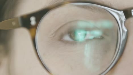 Detail-Eines-Mädchenauges,-Das-Nicht-In-Den-Raum-Blickt,-Durch-Linsen-Und-Brillengestelle-Gesehen,-Weil-Sie-Eine-Brille-Trägt