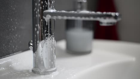 Chrom-Waschbecken-Wasserhahn-Wird-Mit-Reiniger-Besprüht