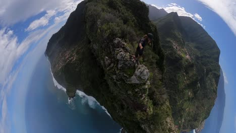 Wide-360-POV-footage-of-a-man-climbing-on-the-edge-of-a-steep-cliff-on-top-of-a-mountain-in-Madeira