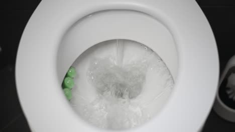 Small-piece-of-toilet-paper-flushed-down-a-white-toilet