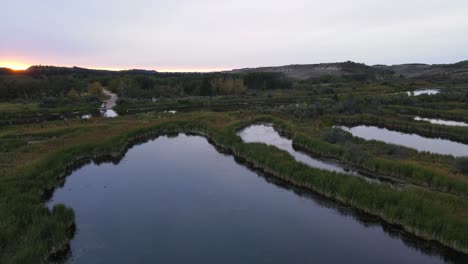 Several-basins-along-the-battle-river-that-build-the-habitat-for-beavers-and-different-birds-with-a-beautiful-sunset-glow-on-the-horizon