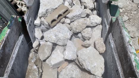 Rocks-and-concrete-being-fed-into-the-jaws-of-a-big-rock-crusher