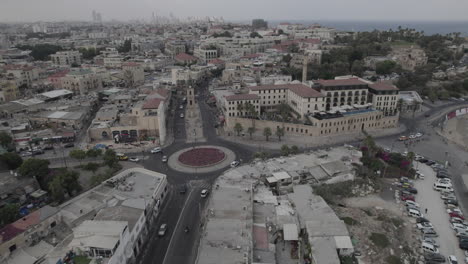 Aerial-view-at-sunrise-over-the-city-of-Jaffa-in-Israel,-passing-over-the-main-square-of-Jaffa-and-the-ancient-clock-tower-of-the-city