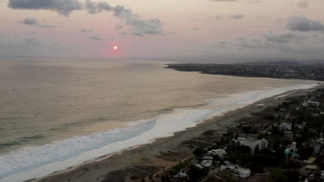 Aerial-is-flying-over-Playa-Zicatela-during-sunset-time,-Puerto-Escondido-Mexico