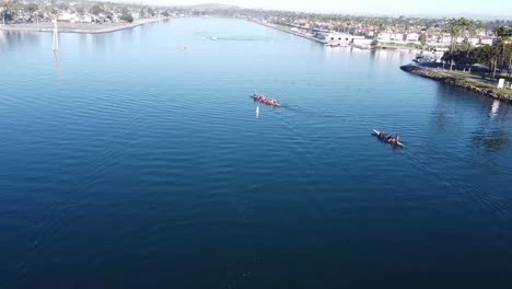Dragon-boaters-paddle-a-cross-the-water-channel,-aerial-view
