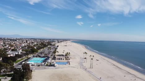 Drone-shot-over-beach-and-a-swimming-pool-by-a-bike-path
