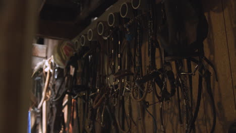 Equestrian-tools-and-equipment-hang-on-the-wall-of-a-rustic-western-horse-barn-1