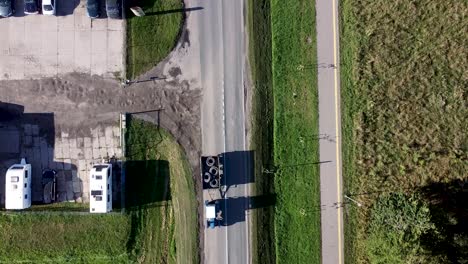 Arial-drone-shot-of-cars-passing-local-business-entrance
