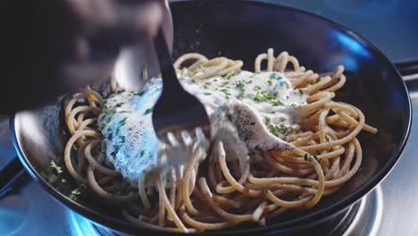 Mixing-Spaghetti-Pasta-In-A-Plate-With-Greek-Yogurt-Sauce-And-Chopped-Parsley