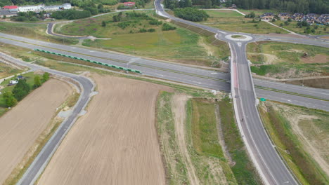 Aerial-View-Of-Roundabout-Interchange-And-Empty-Motorway-At-Daytime
