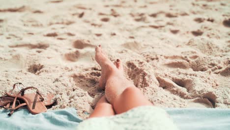 Ich-Perspektive-Einer-Frau,-Die-Sich-Am-Strand-Entspannt,-Während-Sie-Ihre-Beine-Im-Sand-Ausstreckt,-POV-Eines-Touristen-Während-Der-Sommerferien