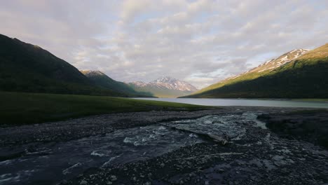 Fast-Flowing-Stream-Against-Mountain-Range-In-Alaska---wide