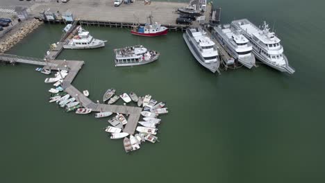 Aerial-view-away-from-a-ferry-docking-at-the-port-of-Plymouth,-USA---tilt,-drone-shot