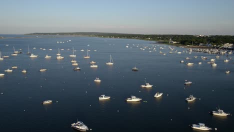 Aerial-view-over-sunlit-boats-anchored-at-the-port-of-Plymouth,-sunny-evening-in-USA