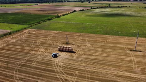 Arial-drone-shot-of-farmer-working-in-the-fields-with-tractor