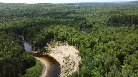 Spectacular-aerial-drone-shot-capturing-natural-formation,-soil-erosion-curve,-river-delta-caused-by-glacier-rivers-at-big-bend,-arrowhead-provincial-park,-Huntsville,-Ontario,-Canada