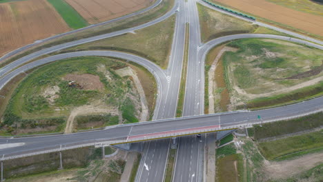 Aerial-View-Of-Empty-Highway-Interchange-Stretching-Through-Rural-Fields