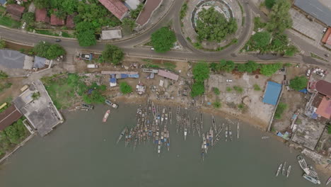 Luftaufnahmen-Von-Oben-Nach-Unten-Einer-Gruppe-Von-Booten-In-Einem-Hafen-Und-Autos,-Die-Eine-Straße-Und-Einen-Kreisverkehr-In-Sierra-Leone-Hinunterfahren