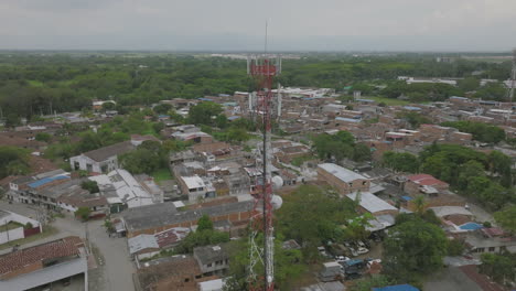 Slow-aerial-flyover-and-gimbal-down-of-a-radio-tower-in-Jamundí,-Colombia