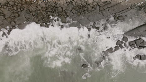 Luftaufnahmen-Von-Oben-Nach-Unten-Von-Meereswellen,-Die-Gegen-Felsen-Prallen