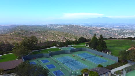 Aerial-View-of-Tennis-Courts-in-Top-of-The-World-Park,-Laguna-Beach,-Orange-County,-California-USA,-Revealing-Drone-Shot