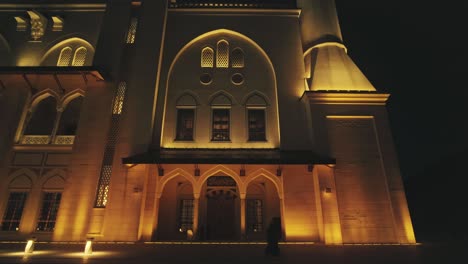 Foto-De-Trípode-De-Adoradores-Caminando-En-El-Patio-De-Una-Gran-Mezquita-Por-La-Noche