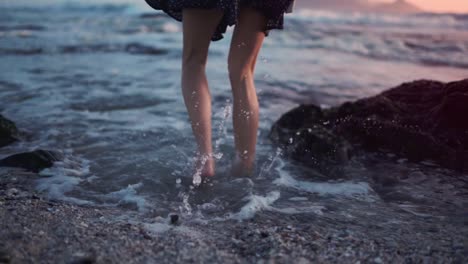 Woman-jumping-on-the-seashore-and-splashing-in-the-salty-water-of-the-sea-waves-as-a-symbol-of-happiness-and-joy