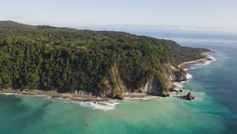 Slow-aerial-view-of-an-ocean-cliff-and-turquoise-waters-in-Osa-Peninsula,-Costa-Rica