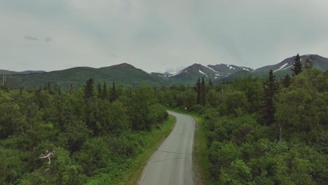 Landstraße-Mit-üppiger-Vegetation-Und-Bergen-Im-Hintergrund-In-Alaska---Luftdrohnenaufnahme