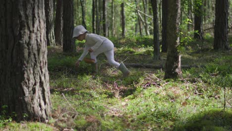 A-young-female-child-is-picking-blueberries-in-a-forest-during-the-summer-in-white-closes