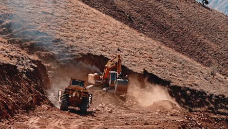 Road-construction-on-top-of-the-mountain-bulldozer-and-tracked-excavator-cutting-the-rocky-soil