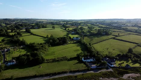 Aerial-view-Traeth-Coch-Pentraeth-farmland-rolling-green-countryside-with-vacation-cottages-along-salt-marsh