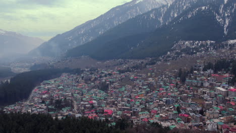 Drone-shot-of-A-village-or-a-small-town-,-between-the-snowy-mountains-of-Himachal-Pradesh-in-india