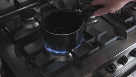 Turning-lpg-gas-hob-on-cooker-produces-large-blue-yellow-orange-flame-under-cooking-pan