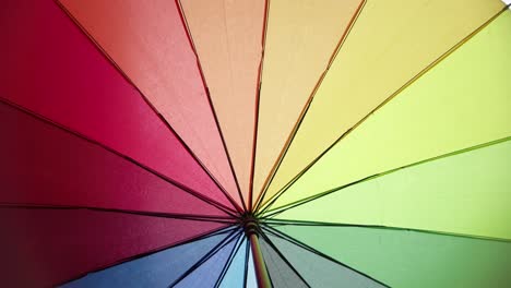 View-under-a-multicoloured-rainbow-umbrella-while-it-is-raining