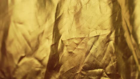 Wrinkled-golden-color-cloth-background-with-changing-light
