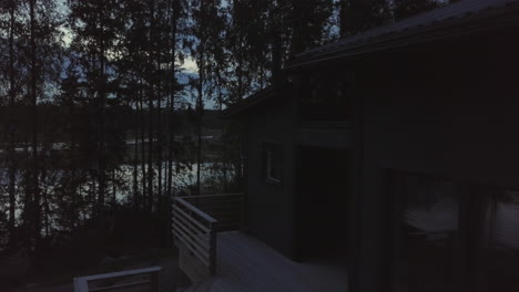 Cozy-Wooden-Cabin-House-by-forest-lake,-late-Summer-Night-in-Finland-Dolly-shot